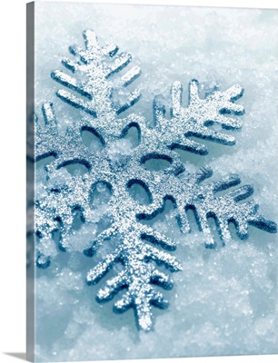 Snowflake Shaped Christmas Ornament Lying In The Snow