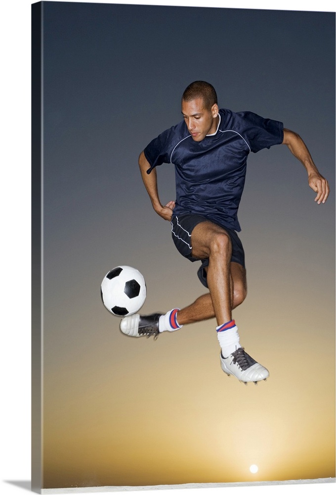Soccer player kicking ball in mid-air
