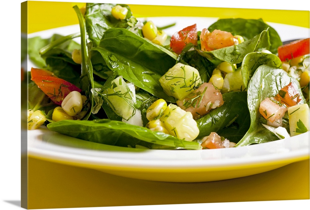 Spinach and sweet corn salad with tomatoes, cucumber and dill, close-up