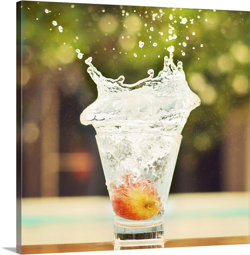 Splash in glass of water with tiny apple. Fresh sensation, end of summer.