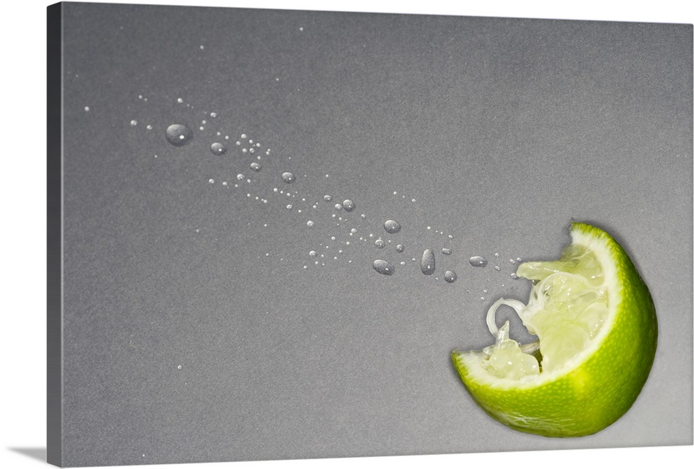 Large canvas photo art of a lime slice with juice coming out on a neutral background.