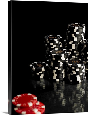 Stacks of black and white gambling chips, red chips in foreground