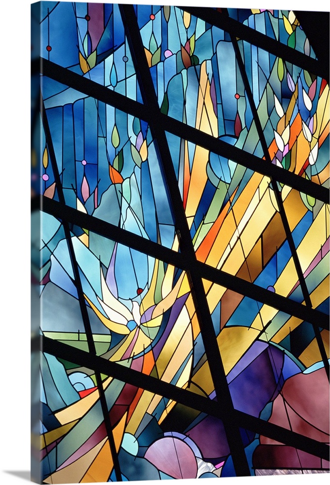 Photograph of a close-up view from below of a bright stained glass window.