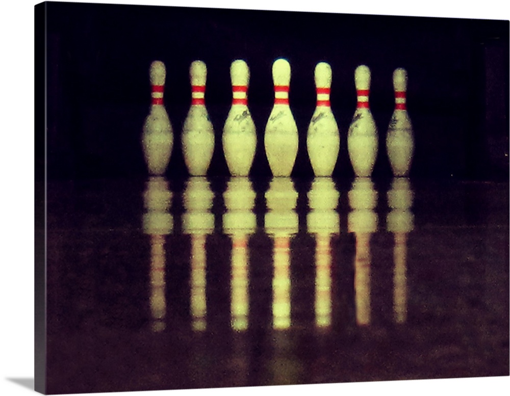 Standing bowling pins with ground reflections.