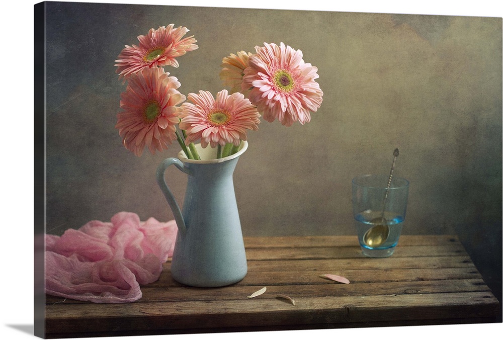 Still life with pink gerberas flowers in blue pitcher jug anf glass of water.