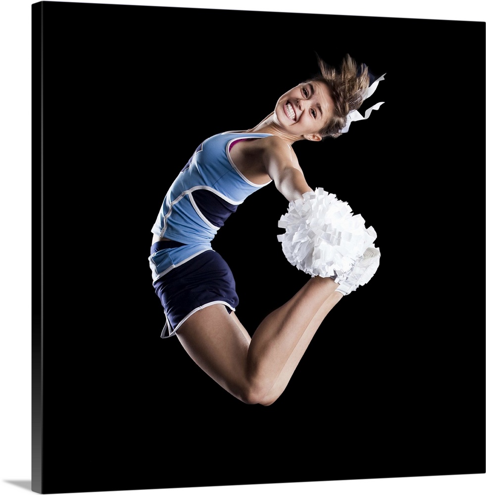 Studio shot of cheerleader (16-17) jumping