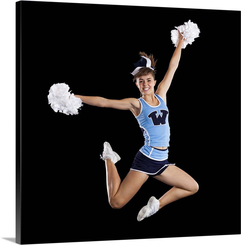 Studio shot of cheerleader (16-17) jumping