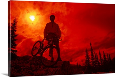 Sun behind cyclist on hill
