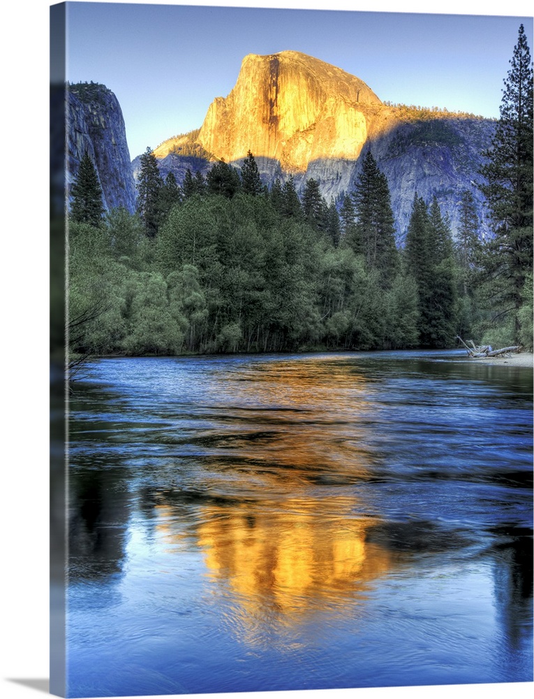 Golden light of sunset on half Dome reflecting in Merced river in Yosemite National Park.