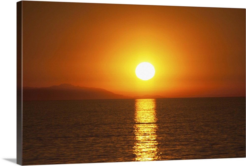 Scenic dark orange sunset over Santa Catalina Island off the coast of California as seen from the Huntington Beach Pier in...