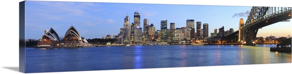 Panorama of Sydney Harbour Bridge at dusk with CBD skyline and the Opera House.