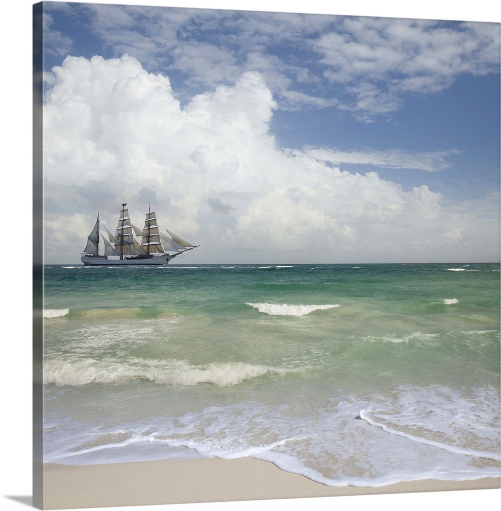 A tall ship sails off shore from a beautiful tropical beach.