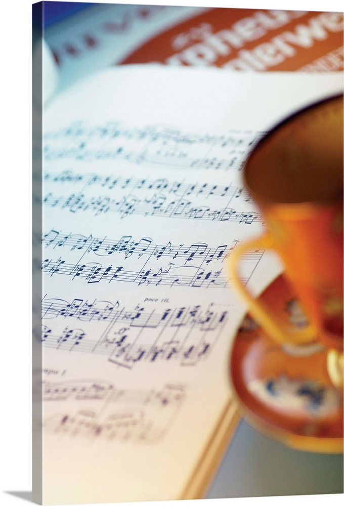 Tea or coffee cup, saucer and sheet music, close-up