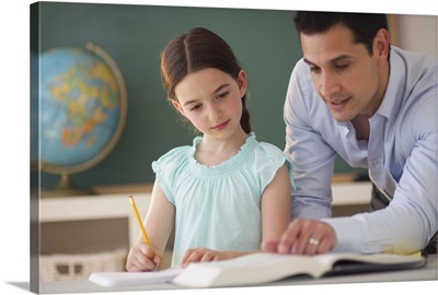 Teacher helping schoolgirl