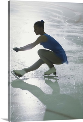 Teenage girl ice skating, side view (blurred motion)