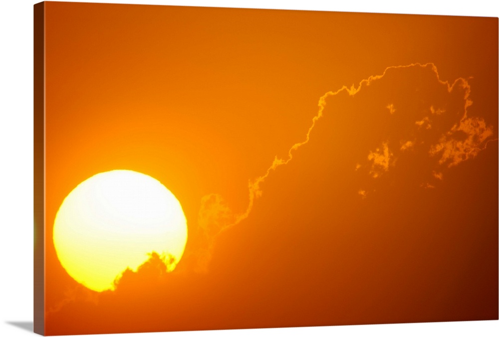 Telephoto view of the rising sun behind orange clouds, Durban, Kwazulu-Natal, South Africa