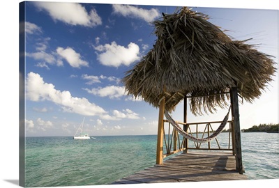 Thatch hut and hammock on dock over the Caribbean