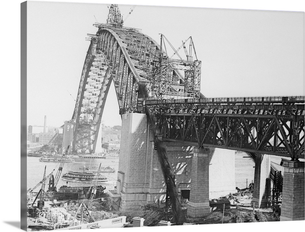 Photo shows the giant steel arch of the Sydney, Australia, Harbor Bridge, as it nears completion. The span is 1650 feet in...