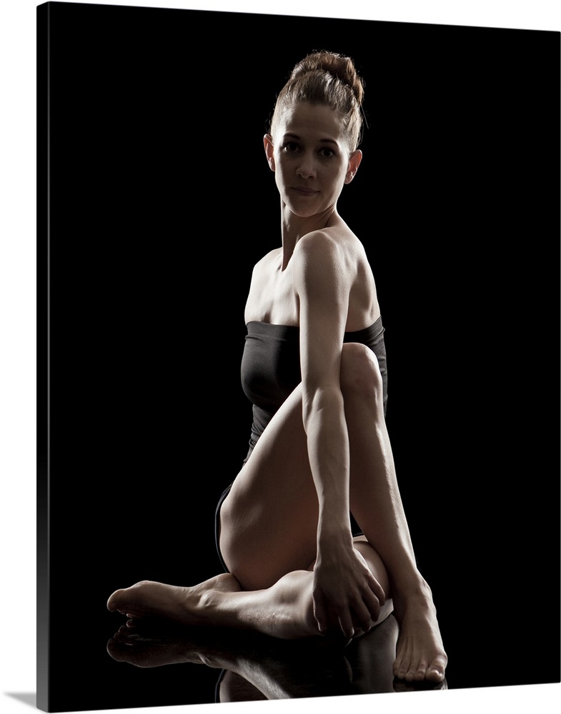 Studio shot of young woman practicing yoga.  The half spinal twist pose, ardha matsyendra asana