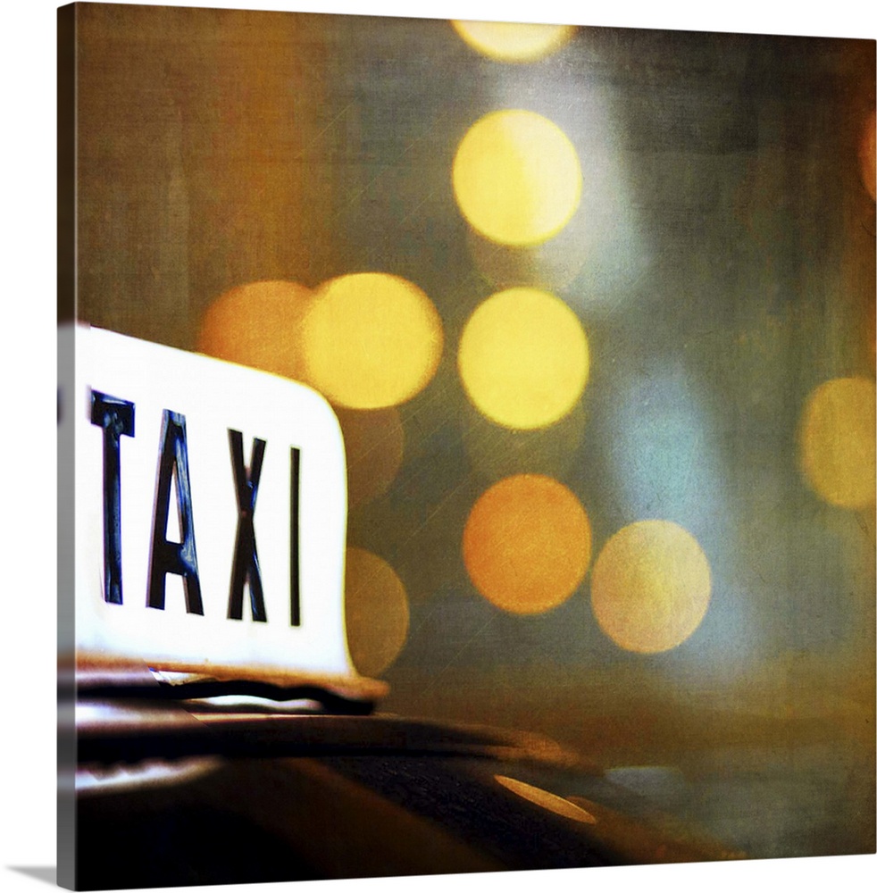 A lit taxi sign is highlighted against the city lights at night.