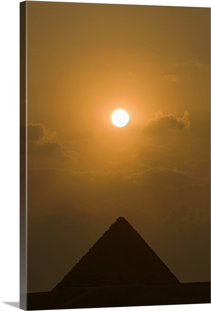 The sun begins to set above The Great Pyramid of Giza, in Cairo, Egypt