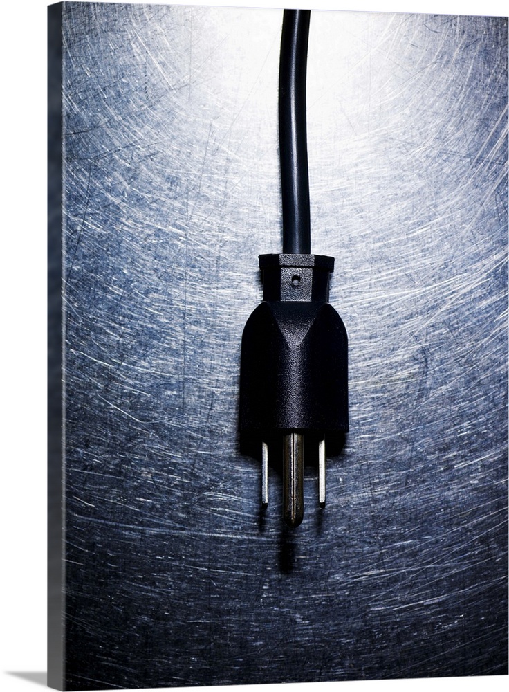 Three-pronged electrical plug on stainless steel.