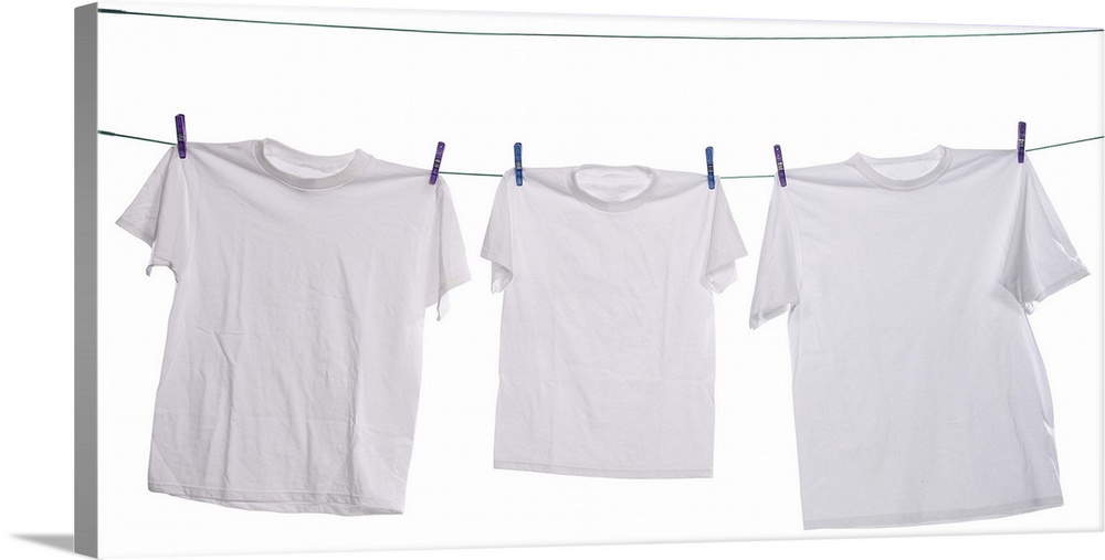 Three white shirts drying on the clothesline