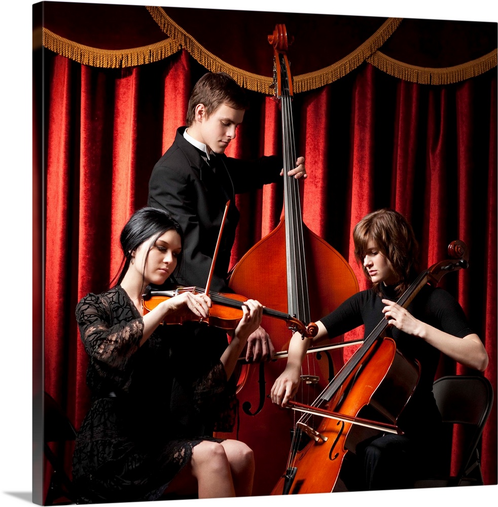 Three young musicians playing in orchestra