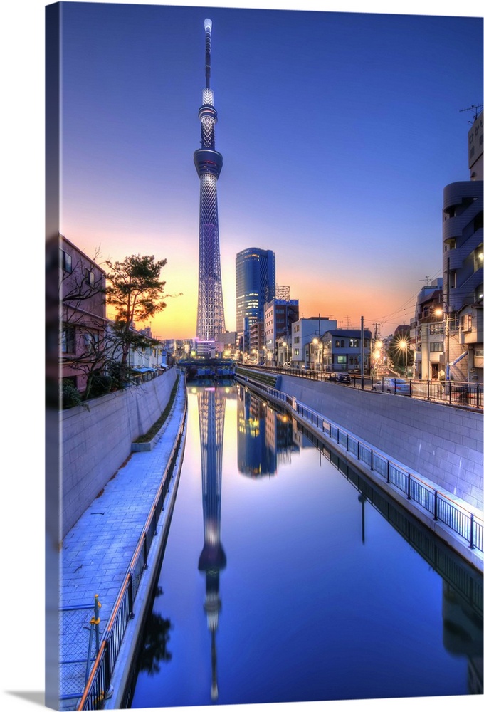Tokyo Sky Tree, Japan's highest tower at 634 meters, is reflected in a canal at sunset.