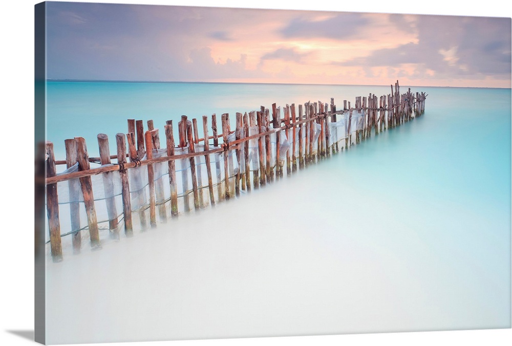 Tranquil scene of Wooden posts in Caribbean sea, at sunset right after storm.