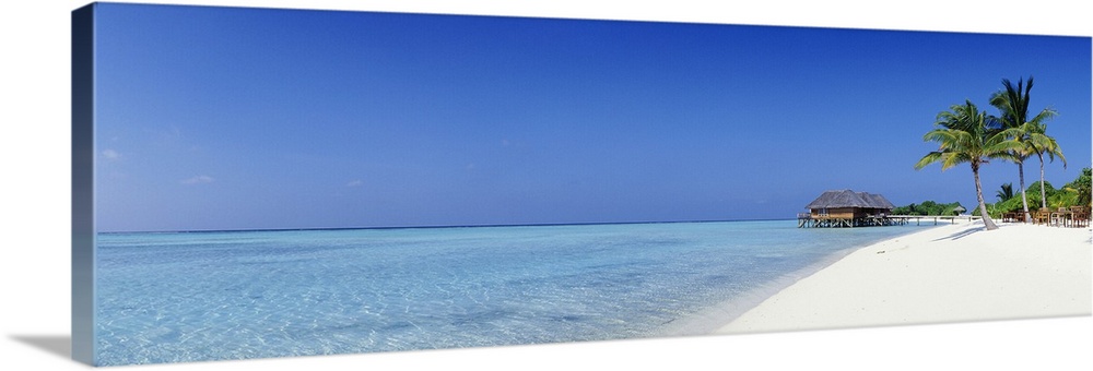 Panoramic image of a tropical beach with white sand and turquoise water.