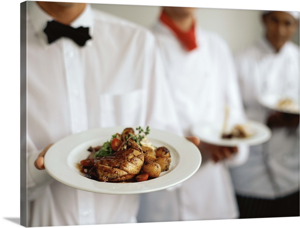 Two chefs and a waiter standing in a row