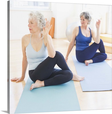 Two senior women practicing yoga