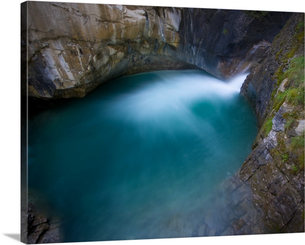 Johnson Canyon, Banff National Park, Canada.  The base of a waterfall flowing into a turquoise pool.