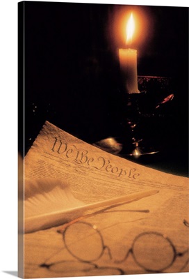 US Constitution with eyeglasses and candle