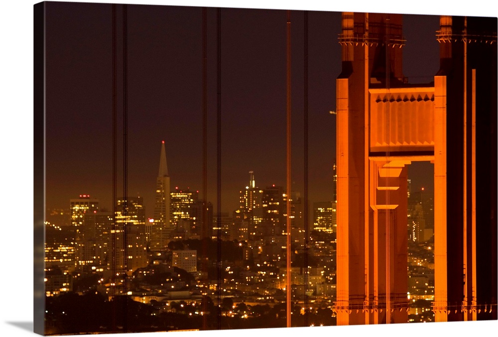 Part of the Golden Gate Bridge and the San Francisco skyline are photographed during the evening with lights illuminating ...