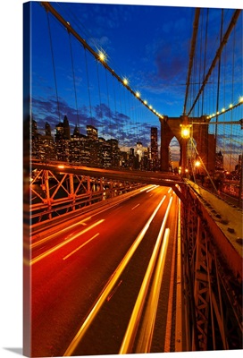 USA, New York City, Brooklyn Bridge with light trails at dusk