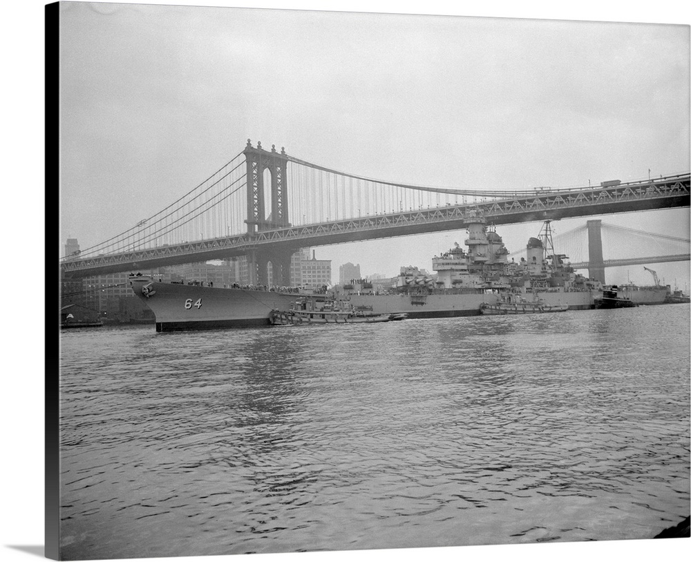 Mighty Wisconsin in Tow. New York: The mighty battleship, USS Wisconsin, is being towed under the Manhattan Bridge by tugs...