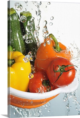 Vegetables in a orange colander, and water