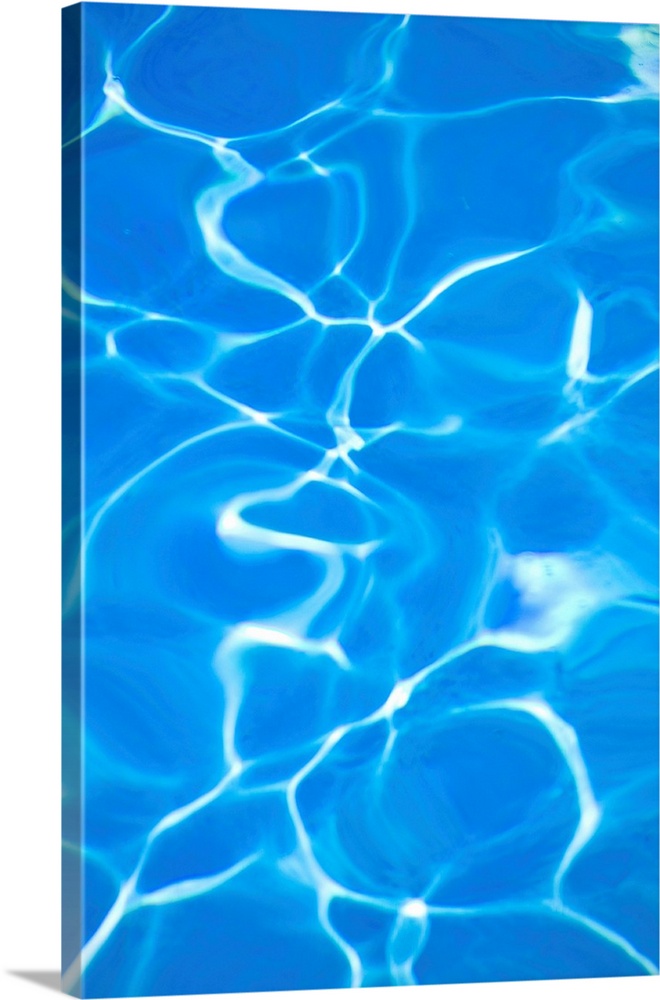 Vibrant blue swimming pool with light refracted through water.