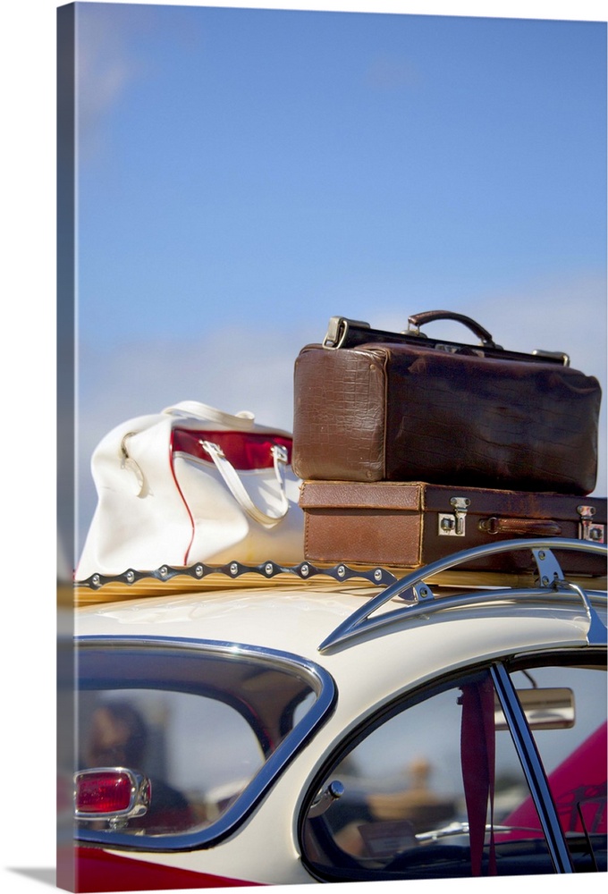 Vintage antique luggage bags on wooden roof rails of old car.
