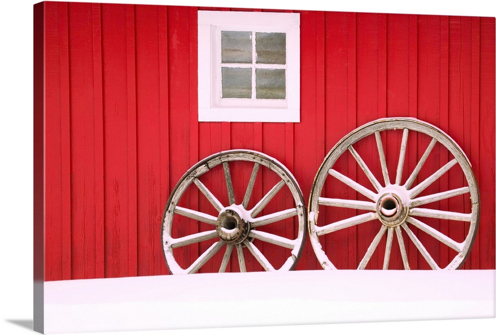 Wagon Wheels On Snow Against Stable
