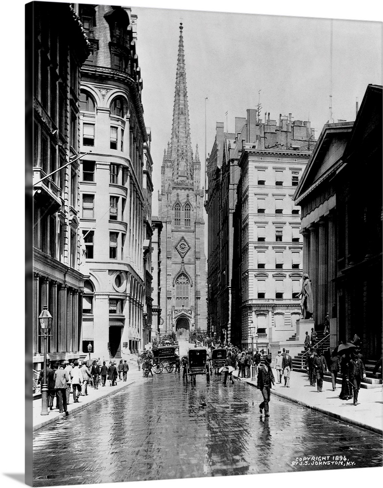 Carriages drive up a wet Wall Street towards Trinity Church. ca. 1894, New York City.
