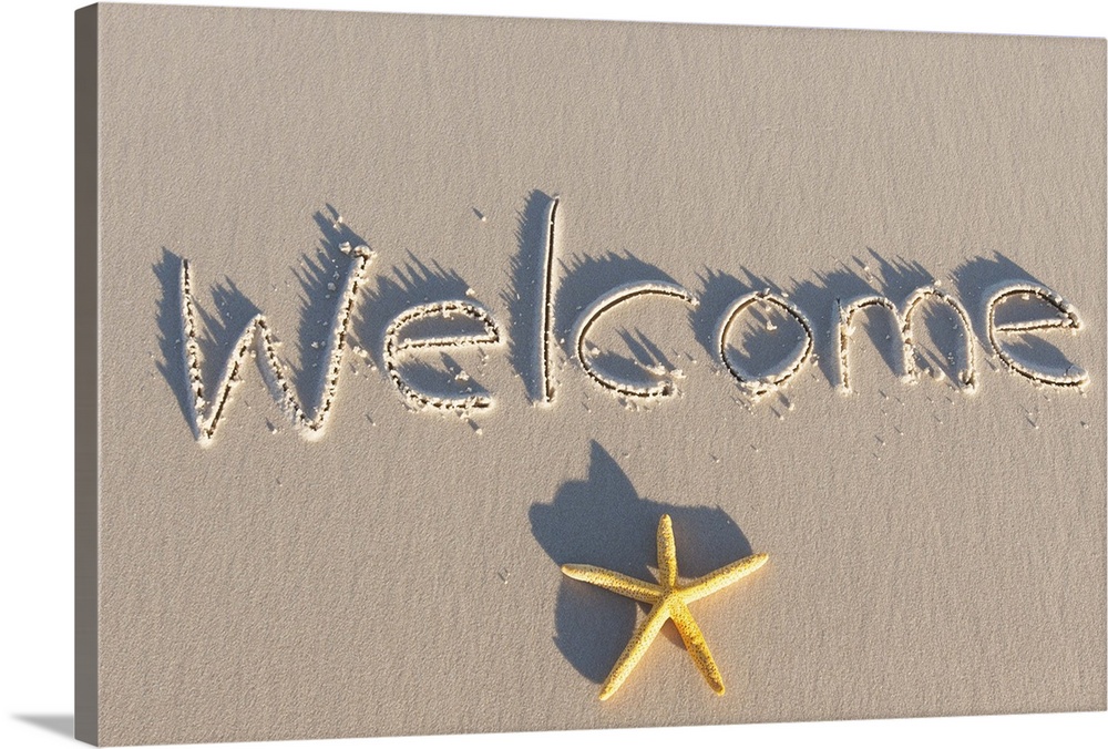 Welcome written on the sand of a beach. Yellow starfish.