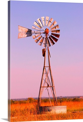 Windmill in pasture land at dawn