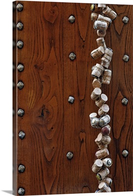 Wine corks hanging on wooden door at Pienza, Tuscany, Italy