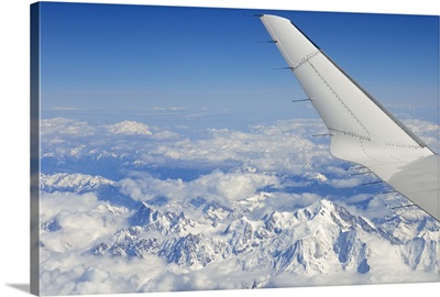 Wings of flying airplane over French Alps, France
