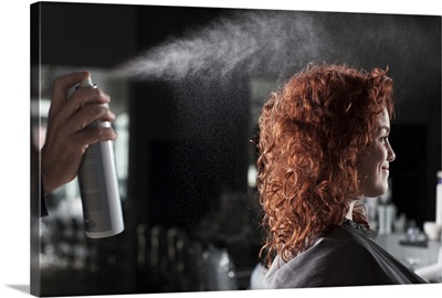 Woman getting hair sprayed at salon