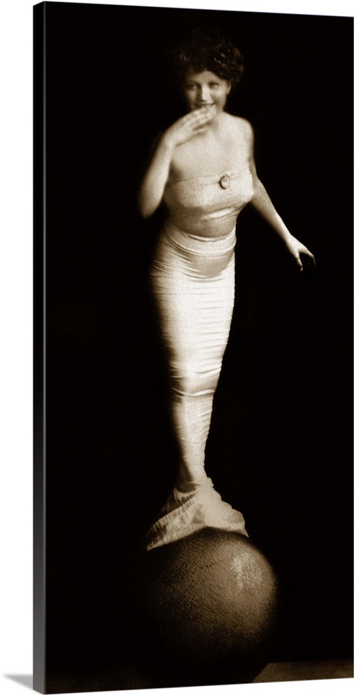 Woman in mermaid costume balancing on ball