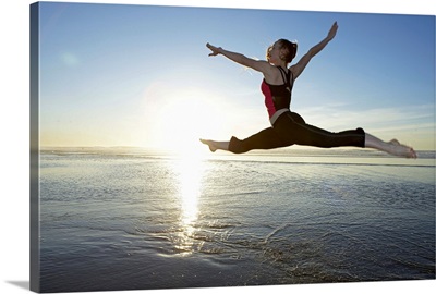 Woman leaping over the ocean